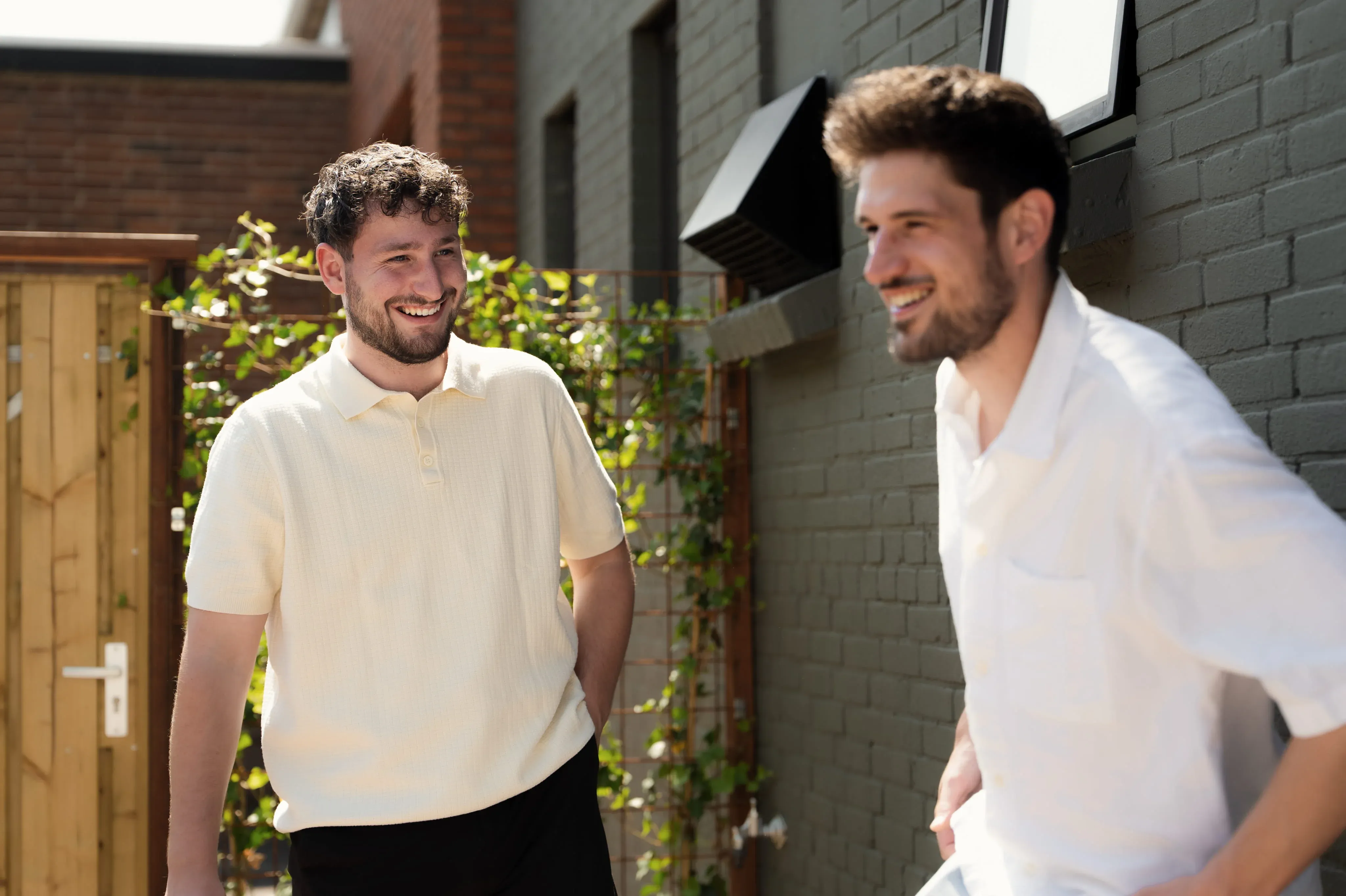 Twee collega's lachen samen buiten het kantoor