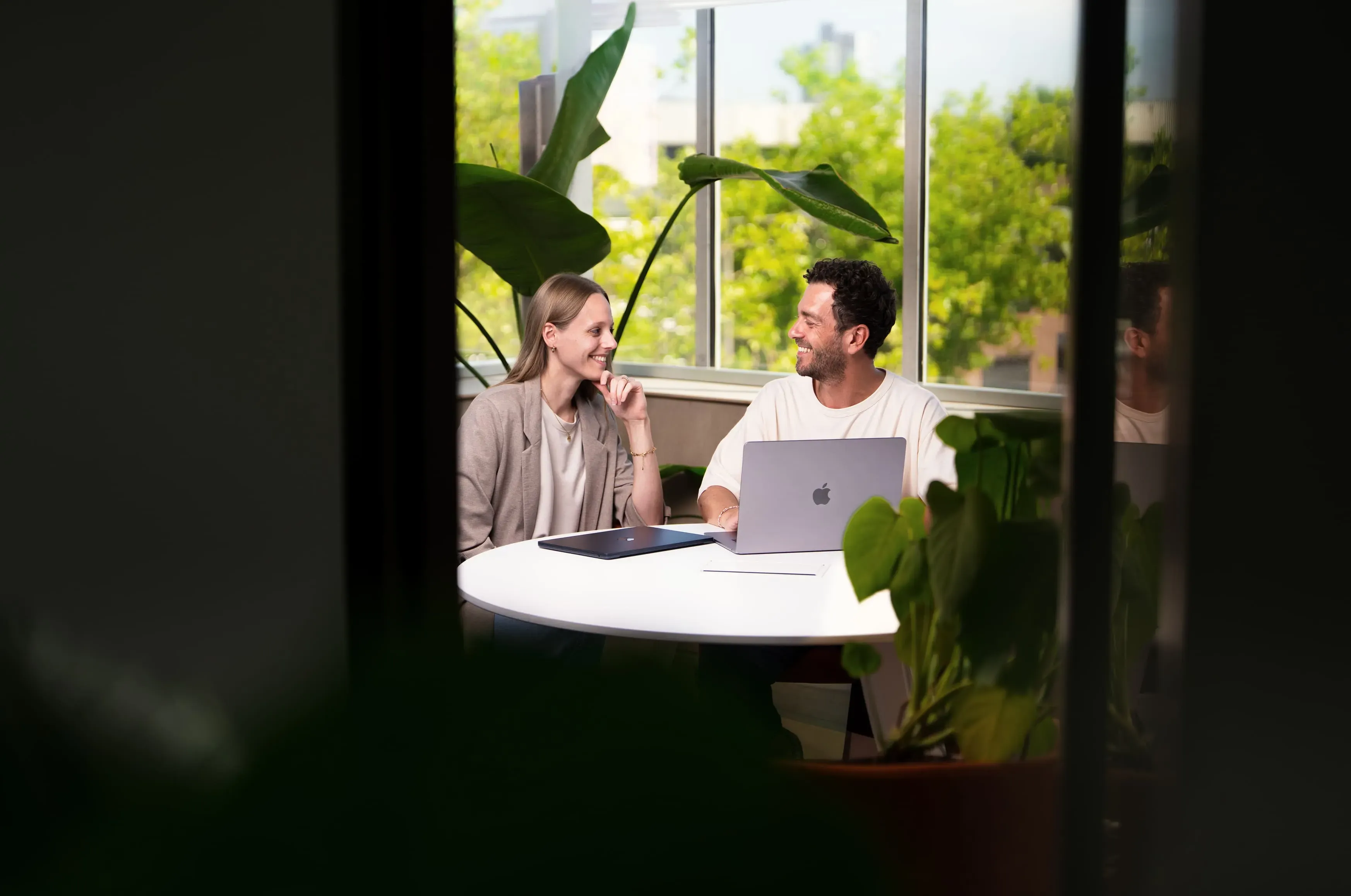 Collega's aan tafel in het lichte kantoor van Mandelo